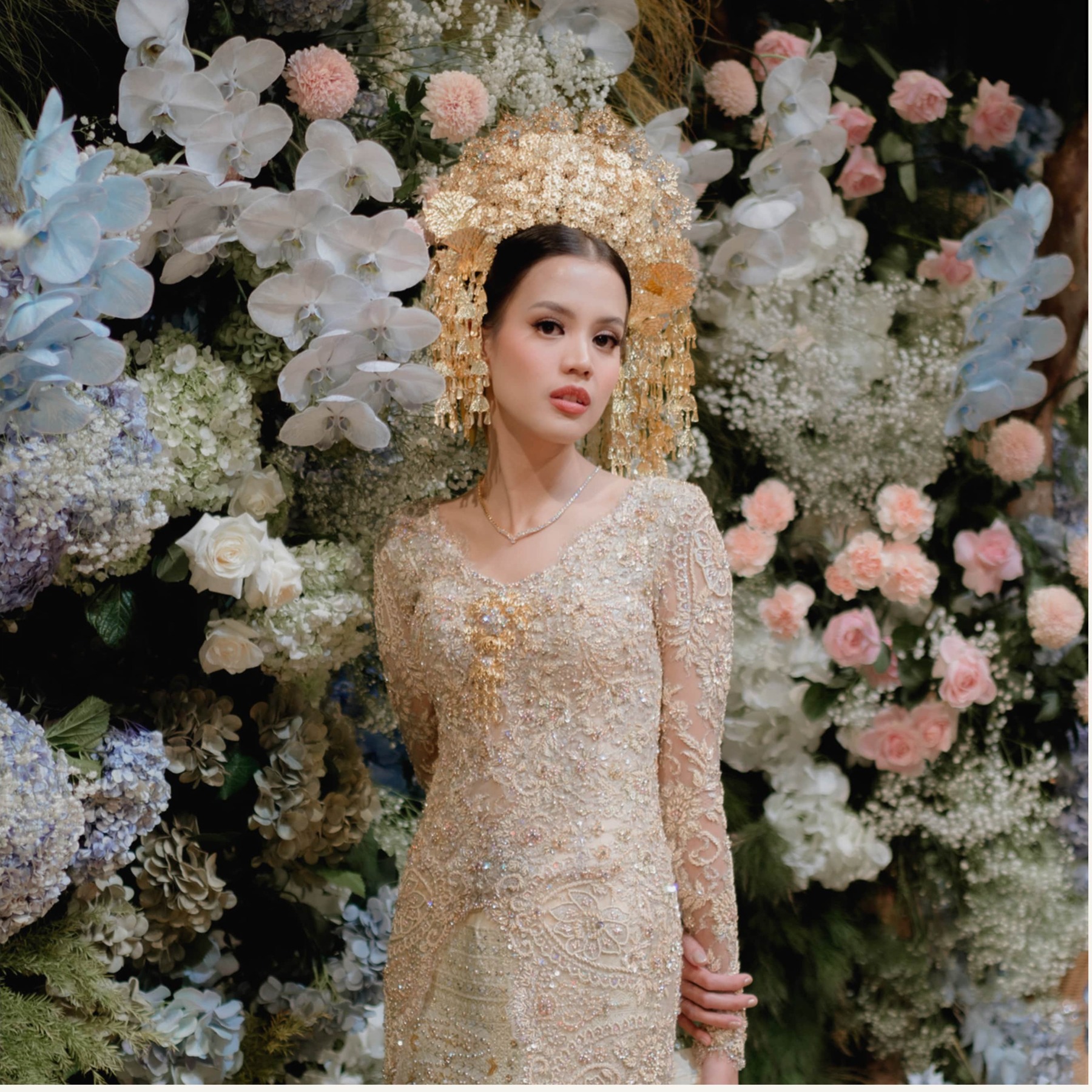 Pengantin dalam busana tradisional berwarna emas