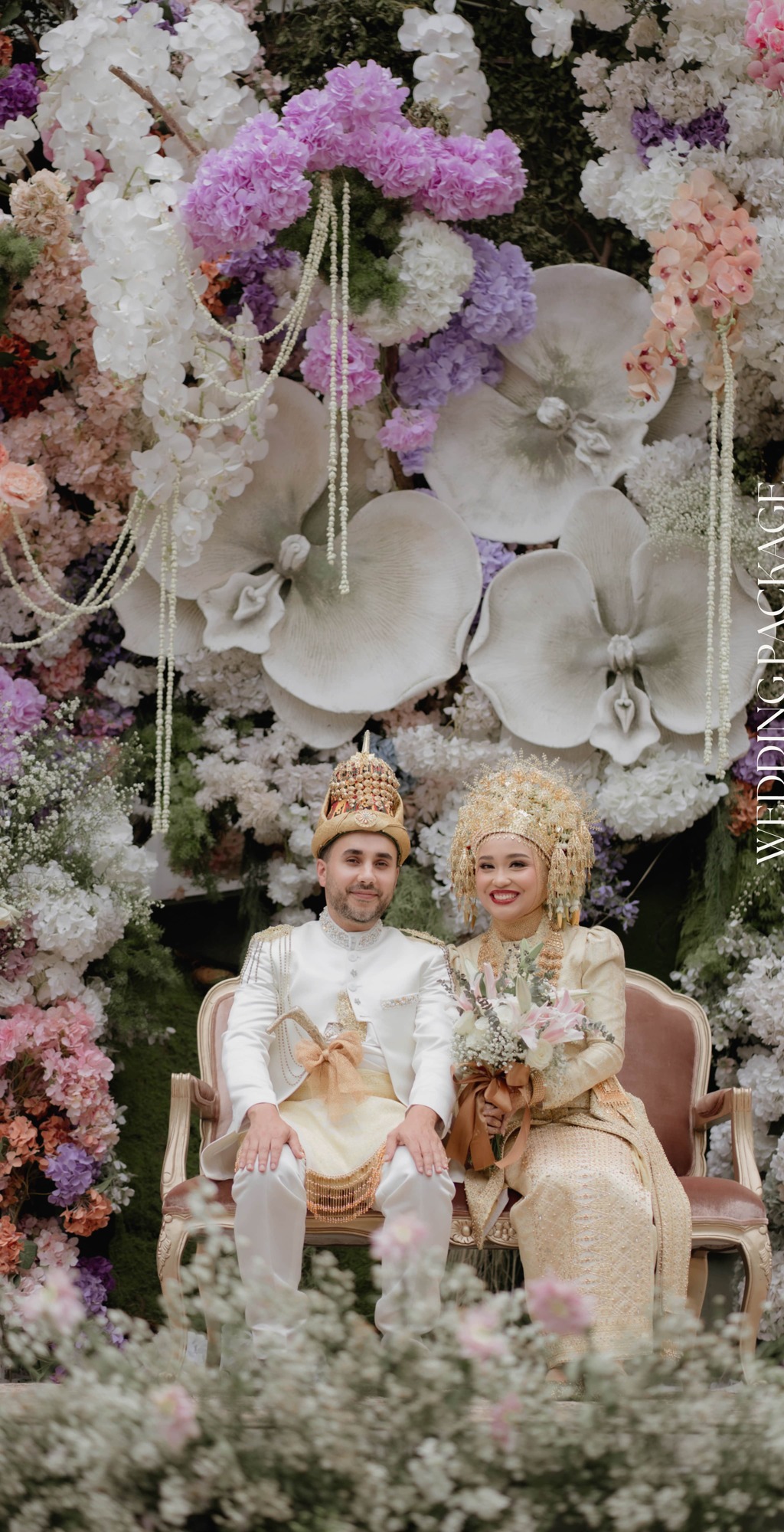 Pasangan pengantin di pelaminan dengan dekorasi bunga